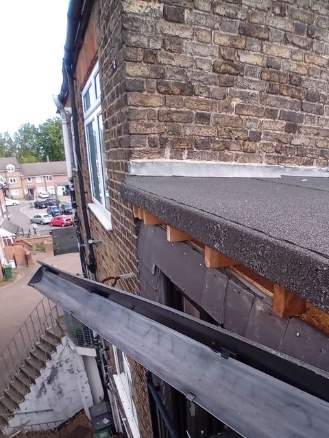 New gutter being fitted along a flat roof edge, Walthamstow
